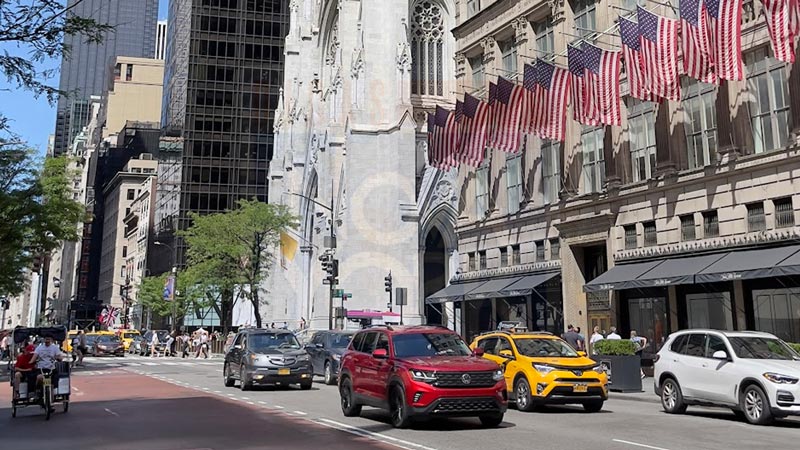 Igreja da Trindade de Nova York no fundo, com carros nas ruas e um taxi amarelo na imagem